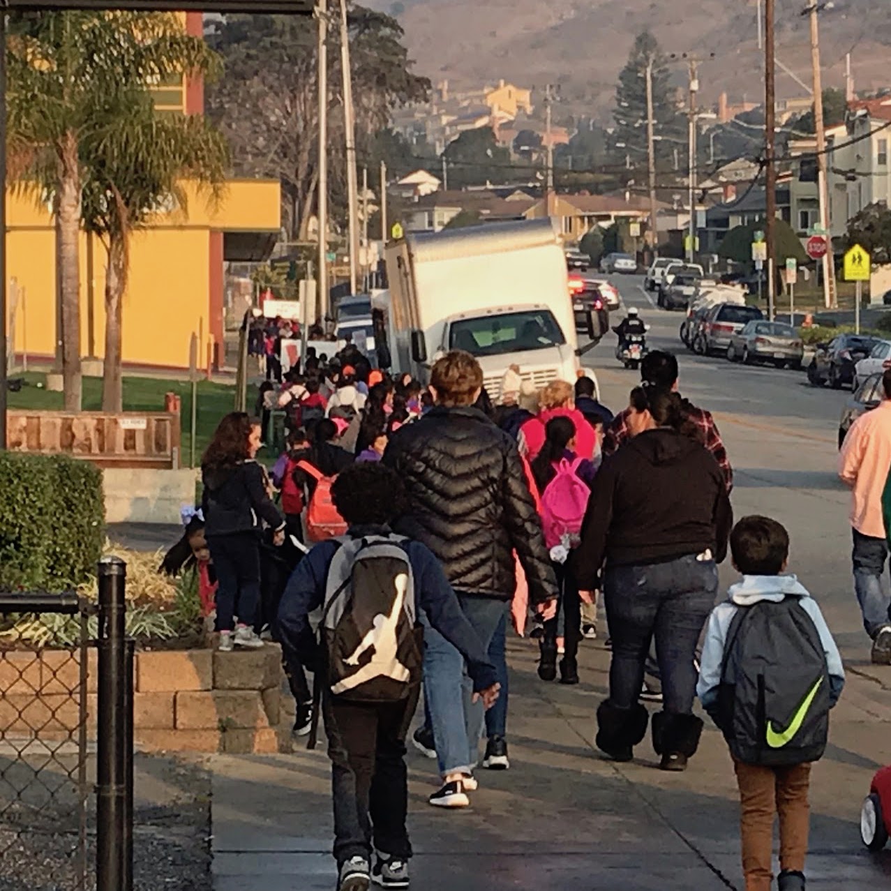 Students and adults walk down the street